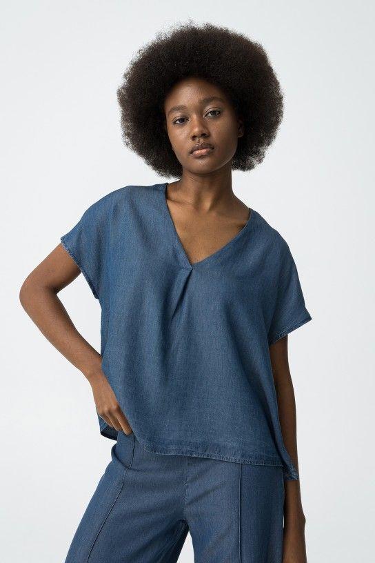 Blusa vaquera con escote en pico y manga corta. 